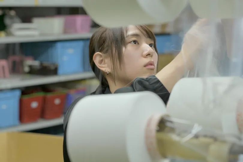 私は数百本の糸からひとつの縦糸を作る作業をしています